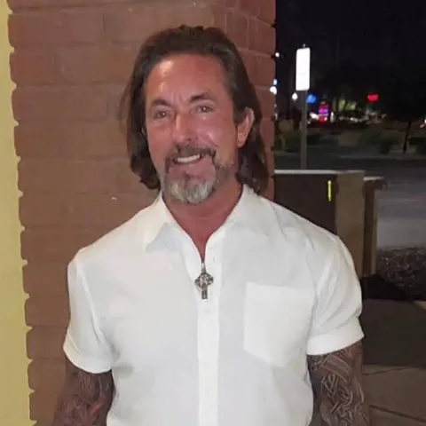Michael Fitzgerald, founder and editor of Phoenix Cooling Guide, smiling in a white short-sleeve shirt outside a Phoenix-area building at night